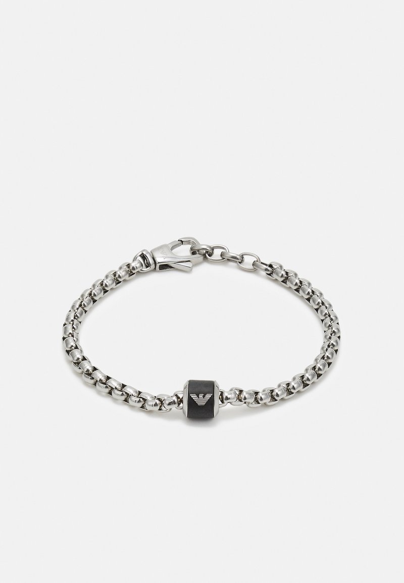 Sølvkjedearmbånd med et svart rektangulært anheng med logo, festet med en lås. Lenkene er glatte og metalliske.