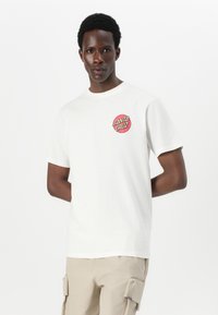 White cotton t-shirt featuring a circular red graphic with "SANTA CRUZ" text. The design has a crew neckline and short sleeves.