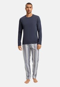 Navy blauwe longsleeve shirt gecombineerd met gestreepte pyjamabroek in lichtblauw, grijs en wit. Soepele stof met elastische tailleband.