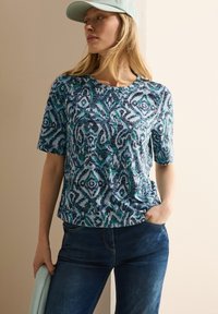 Maglietta a maniche corte con un motivo astratto blu e verde, realizzata in tessuto morbido, con scollatura rotonda e vestibilità comoda.