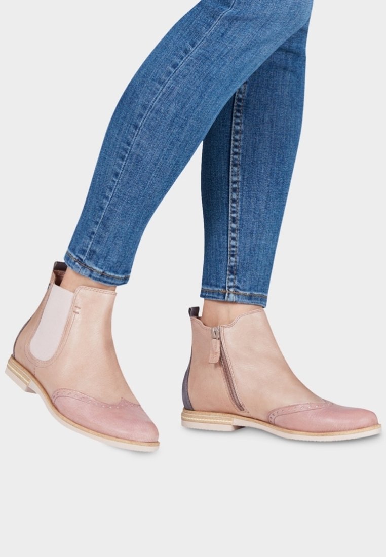 Zweifarbige Leder-Stiefeletten in Hellrosa und Beige. Mit seitlichem Reißverschluss, runder Zehenpartie und dekorativen Brogue-Details. Holzsohle.