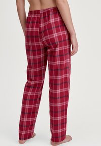Rode geruite pyjamabroek van zacht stof, met een relaxte pasvorm, elastische tailleband en contrasterend zwart-wit geblokt patroon.