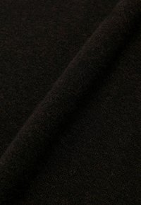 Zwarte wollen stof, met een textuur die zachtheid en warmte toont, met een soepele rol die rijke vezels en een consistente kleur benadrukt.