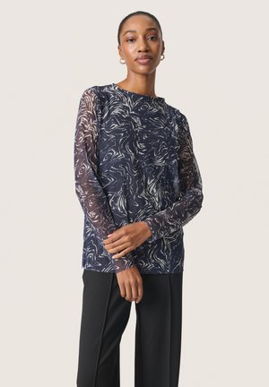 Maglietta a manica lunga blu navy con un motivo bianco a spirale e maniche trasparenti. Il design presenta un collo rotondo e una vestibilità comoda.