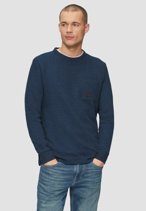 Marineblauwe sweatshirt met lange mouwen en ronde hals, met een gestructureerde afwerking en een borstzak, gedragen met lichtblauwe denim jeans.