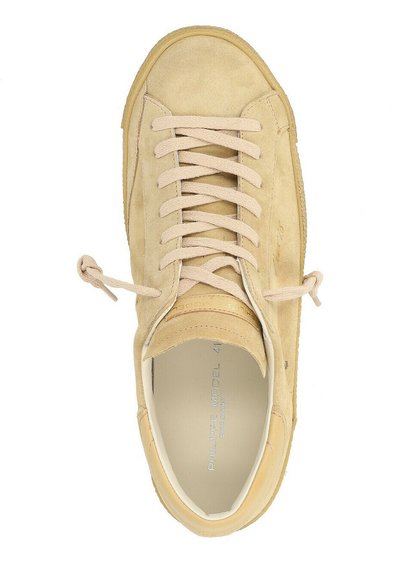Sneaker in suede beige con lacci piatti, punta arrotondata e suola in gomma. Presenta un logo sulla suola intermedia e dettagli di cucitura minimali. Design semplice e leggero.