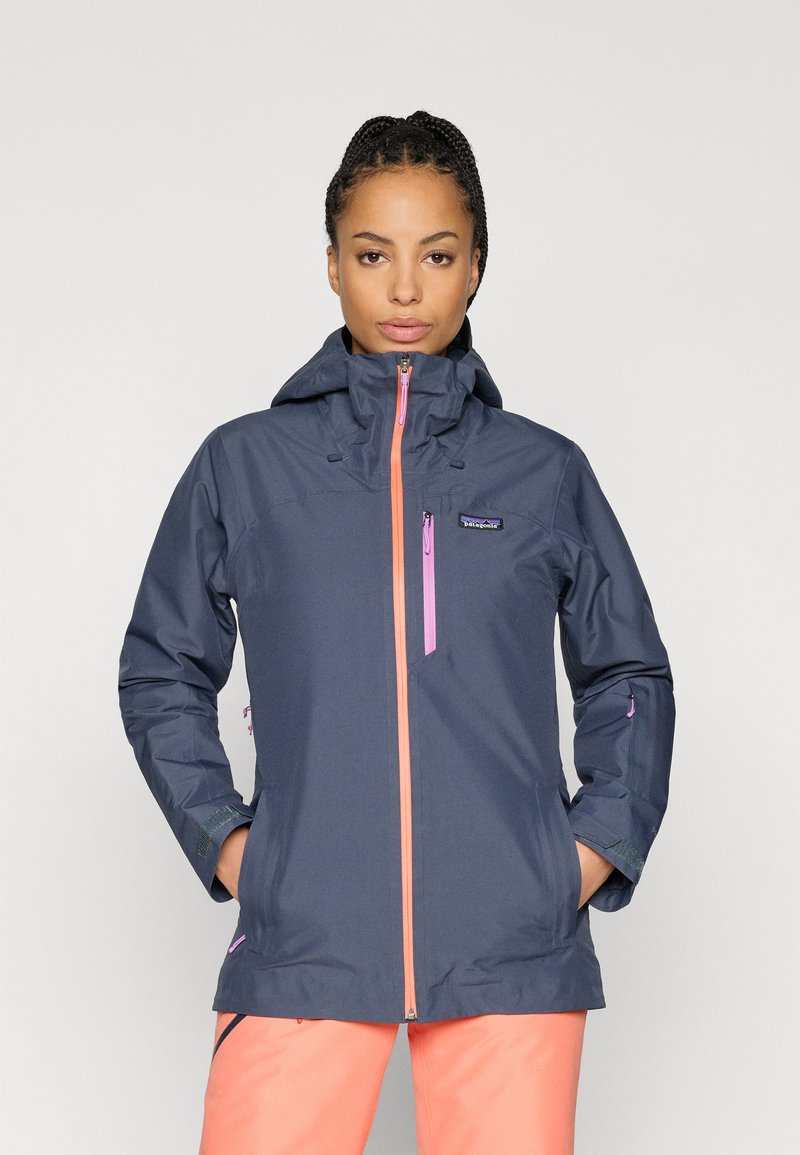 Αδιάβροχο ναυτικό μπουφάν με κουκούλα, διαθέτει ροζ φερμουάρ και λεπτομέρειες, ρυθμιζόμενους καρπούς και μπροστινές τσέπες. Μαλακή υφή, σύγχρονος σχεδιασμός.