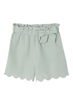 Hellgrüne Shorts aus strukturiertem Stoff mit Paperbag-Taille, wellenförmigem Saum und dekorativer Schleife auf der rechten Seite.