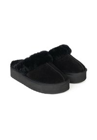 Pantofole in suede nero con un morbido polsino in pelliccia sintetica nera, suola piatta e dettagli cuciti lungo i bordi. Il design è open-toe e slip-on.