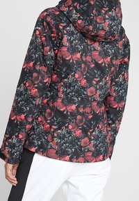 Blumenmuster-Jacke mit schwarzem Hintergrund, ausgestattet mit roten und grünen Akzenten, einer Kapuze und einem strukturierten, glatten Material.