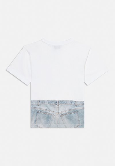 Hvit t-skjorte med korte ermer med trykt design av blå denimjeans og baklommer langs den nedre halvdelen.