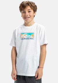 Vit bomullströja med en färgglad rektangulär grafisk logotyp med vågor och berg, korta ärmar och en avslappnad passform.
