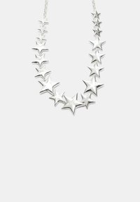 Hopeinen tähtiä muistuttava kaulakoru, joka koostuu 15 kiiltävästä metallitähtisestä, jotka vaihtelevat koossa ja ovat yhdistetty hienolla ketjulla. Pintakäsittely on sileä ja heijastava.