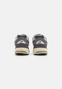 Šedé a námořnické tenisky s svrchním materiálem z semiše a síťoviny, polstrovaným límcem, vysoce odpruženou podrážkou a perforovanými detaily. Na patě je logo.