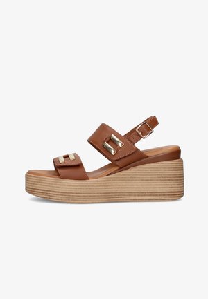 Sandalo zeppa in pelle marrone con due cinturini con fibbie dorate e cinturino regolabile alla caviglia, con suola platform stratificata con texture effetto legno.