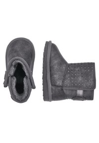 Černé kotníkové boty vyrobené z měkké texturované tkaniny. Zahrnují design s přehnutím, perforované detaily a robustní gumovou podrážku. Podšívka vnitřku.