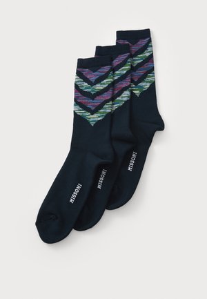 Tre par navy sokker med flerfargede chevron-mønstre nær toppen og hvit "MISSONI" tekst på sålene.