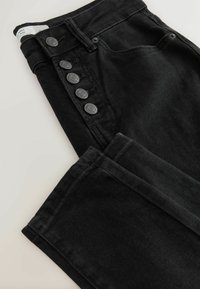 Melni denima bikses ar augsto jostas dizainu, piecas sudraba tonī pogas gar sāniem un mīksta, gluda tekstūra.