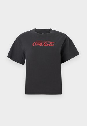 Svart bomull T-skjorte med korte ermer, med en rød Coca-Cola-logo og tekst over brystet. Klassisk rund hals, avslappet passform.