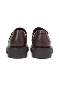 Scarpe in pelle bordeaux con finitura liscia, caratterizzate da un design elegante, con colletto imbottito e suola spessa in gomma nera. Logo impresso sul tallone.