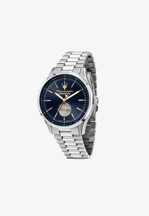 Montre en acier inoxydable avec un cadran bleu, des index dorés et un design à cœur ouvert. Elle est dotée d'un bracelet à maillons et d'une couronne sur le côté.