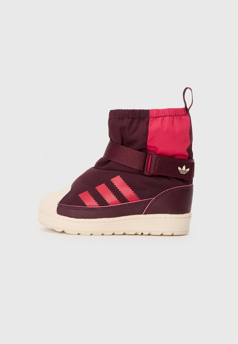 Burgundi és rózsaszín szigetelt csizma steppelt tetejével, gumitalppal, három átlós csíkkal és állítható pánttal. Mintás talp a tapadás érdekében.