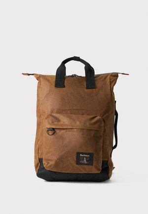 Bruin gewaxed canvas rugzak met zwarte bodem, bovenhandgrepen, voorzak en verstelbare schouderbanden. Heeft een vierkante vorm en een gestructureerd oppervlak.