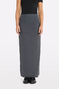 Maxihame made of dark gray fabric with floral embroidery, fitted at the waist, smooth texture, paired with black shoes.