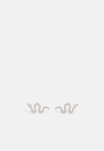 Boucles d'oreilles en argent scintillant en forme de serpent avec un détail de queue pointue sur fond blanc.