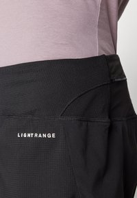 Juodi sportiniai šortai su tekstūruotu juosmeniu. "LIGHTRANGE" prekės ženklas baltos spalvos. Lygus audinys, prigludusi dizainas ir subtilūs siūlai.