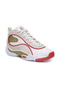 Valge, beež ja punane sportlik sneaker kuldsete aktsentidega, lipsude kinnitusega disain ning paks valge tald punase varbakatte ja kanderaudadega.