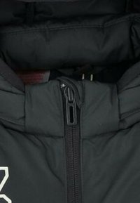 Giacca a vento nera imbottita con colletto alto, chiusura frontale con zip e texture liscia. Include logo visibile sulla parte sinistra del petto.
