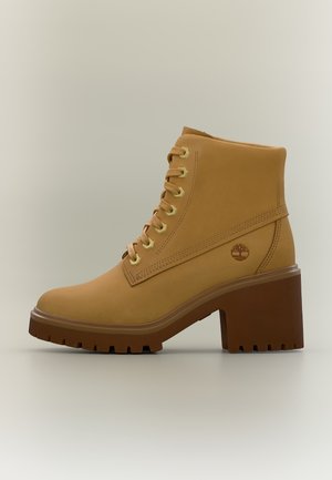 Bottine à lacets en cuir fauve avec talon haut et épais et semelle robuste sur fond uni.