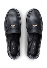 Μαύρα δερμάτινα μοκασίνια με εμφανή ραφές, διακοσμητικό μεταλλικό στοιχείο και επένδυση με μαξιλάρι που διαθέτει διάτρητα σημεία.