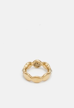 Guldring med et glat, afrundet design med skiftende kurver. Inkluderer en lille klar ædelstenaccent på den ene side.