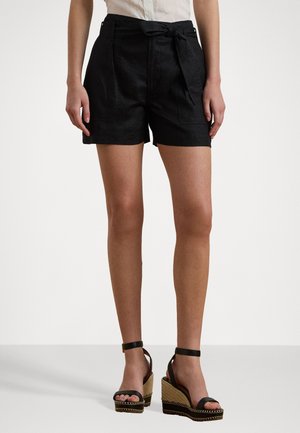 Shorts negri din in cu talie inalta, curea legata si buzunare laterale; purtati cu sandale cu toc inalt negre, cu talpa tesuta.
