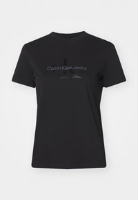 Czarna bawełniana koszulka z okrągłym dekoltem, krótkimi rękawami i błyszczącym czarnym logo "CK" z napisem "Calvin Klein Jeans" poniżej.