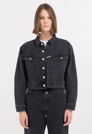 Veste cropped en denim noir avec fermeture à boutons, deux poches poitrine et un col classique. Présente une coupe décontractée et une surface texturée.