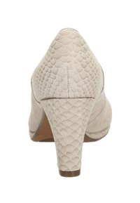 Chaussure à talon haut beige avec un motif texturé en écailles. Dotée d'un bout pointu et d'un talon solide, fabriquée en matériau doux.