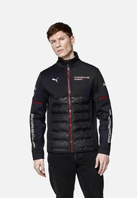 Czarna kurtka z wyściełanym przodem, czerwonymi akcentami i logo. Wykonana z mieszanki materiałów, z zapięciem na zamek i wysokim kołnierzem.