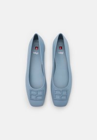 Pár světle modrých kožených slip-on balerín se čtveratými špičkami a vystouplým geometrickým vzorem na přední části, značené "högI" uvnitř.