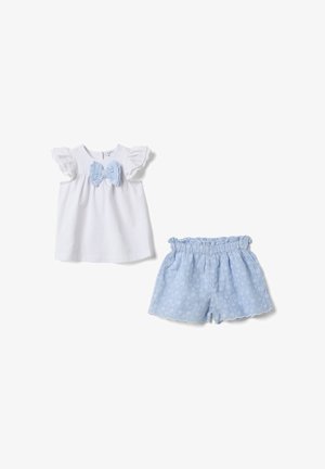 Camiseta blanca de manga corta para niño pequeño con mangas de volantes y lazo azul bordado, combinada con pantalones cortos azules con cinturilla elástica y estampado floral de ojales.