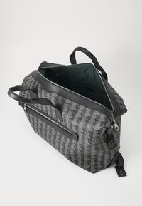 Gray patterned bag with a black leather trim, top zipper, dual handles, and an interior pocket, featuring a geometric design on the exterior.