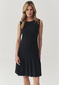 Marineblaue ärmellose Kleid mit vertikalen Falten, A-Linien-Form, knielanger Saum und glatter Stofftextur. Schlichter Ausschnitt ohne Verzierungen.