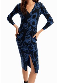 Czarna sukienka w prążki z niebieskim abstrakcyjnym wzorem, dekoltem w serek, długimi rękawami, zapięciem na guziki z przodu oraz bocznym rozcięciem dla dodania szczegółu.
