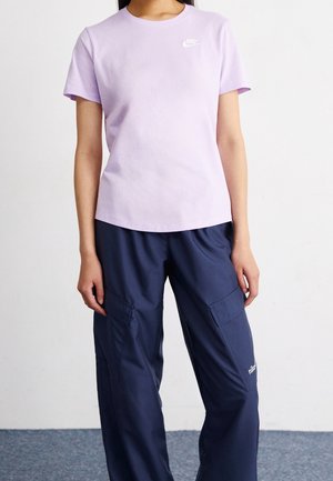 Light purple cotton t-shirt with a crew neck and white Nike logo, paired with navy blue cargo pants featuring large pockets.