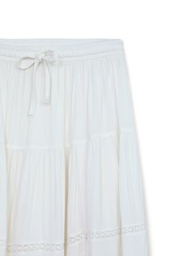 Gonna bianca in cotone con un design a strati, vita elasticizzata e laccetto regolabile. Presenta dettagli in pizzo sui livelli per un tocco in più.