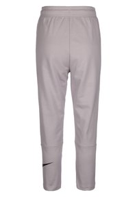 Pantalons de sport gris clair avec une taille élastique et une longueur courte. Présente un logo Nike noir sur le bas de la jambe gauche. Texture lisse.