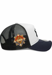 Gorra de camionero con frente blanco, parte trasera de malla negra y visera azul marino. Presenta un logo bordado con las palabras "Yankee Stadium" y "World Series".