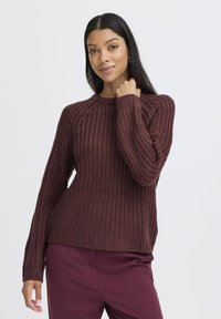 Burgunderfarbener Strickpullover mit strukturiertem Muster, gerippten Bündchen und Ausschnitt. Mit lockerer Passform und leicht herabgesetzten Schultern.